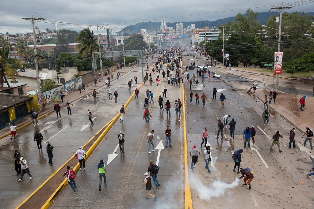 Supporters of Libre Alliance presidential candidate Salvador Nasralla throw rocks at riot police